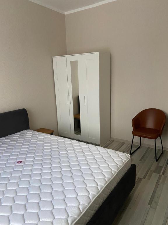 a bedroom with a bed and a chair and a mirror at Straume AP in Valmiera