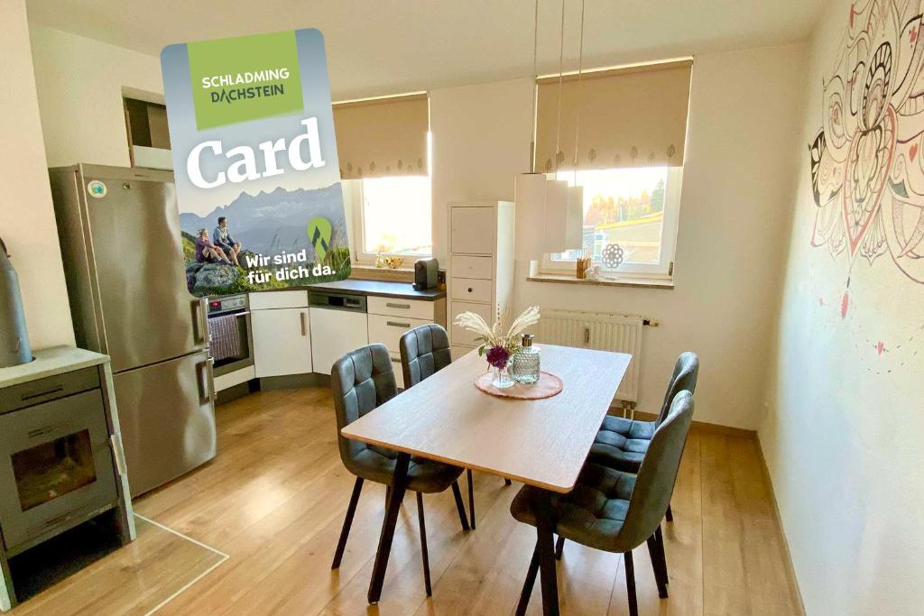 a kitchen with a table and chairs and a refrigerator at Ferienwohnung Maria - by myNests in Haus im Ennstal