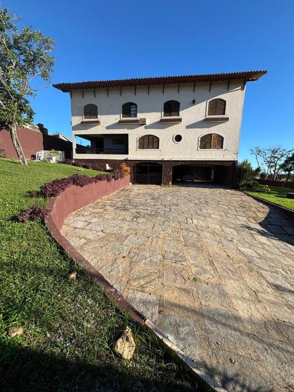 a large white building with a large driveway at Caminho das Pedras 206 in São Pedro da Aldeia