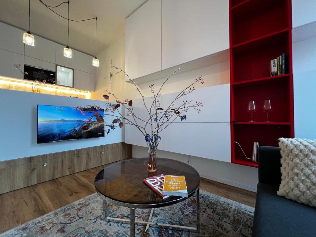 a living room with a table with a vase on it at TUGENDHAT Boutique Suite in Komárov
