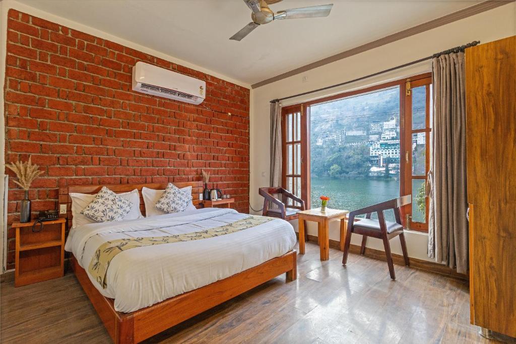 a bedroom with a brick wall and a bed and a window at By the Lakeside in Bhīm Tāl