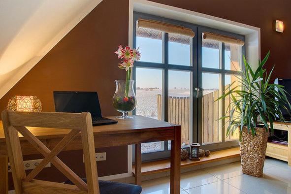 a room with a desk with a laptop and a window at Dreiurtshof Fewo 2 in Remplin