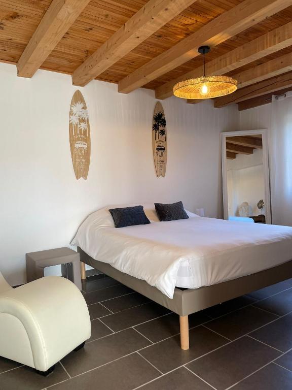 a bedroom with a large bed and a chair at Escapade Maritime in Dompierre-sur-Mer