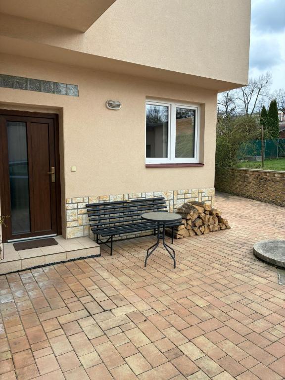 a patio with a bench in front of a house at Apartmán Ševcovská in Zlín