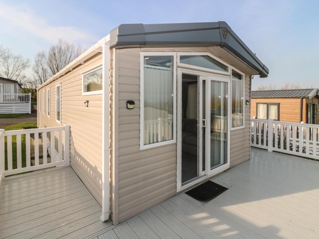 a tiny house with a door on a deck at Plot 243 - Coldingham Bay Leisure Park in Eyemouth