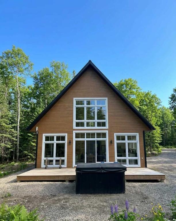 a house with a large window on the front of it at Spa Lakeside & Adventure - Nature Chic in Saint-Michel-des-Saints