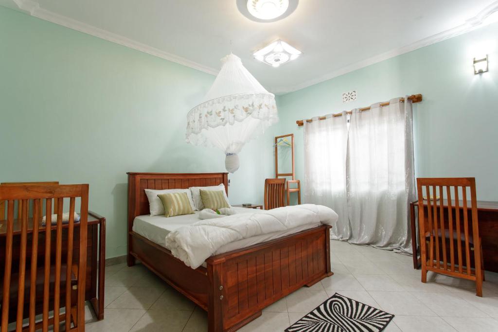 a bedroom with a bed and a chandelier at Silent Patner Lodge in Arusha