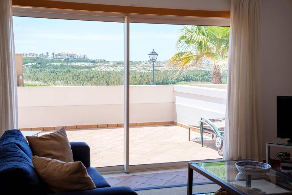 a living room with a large sliding glass door at Vila da Praia 462-C01 in Óbidos
