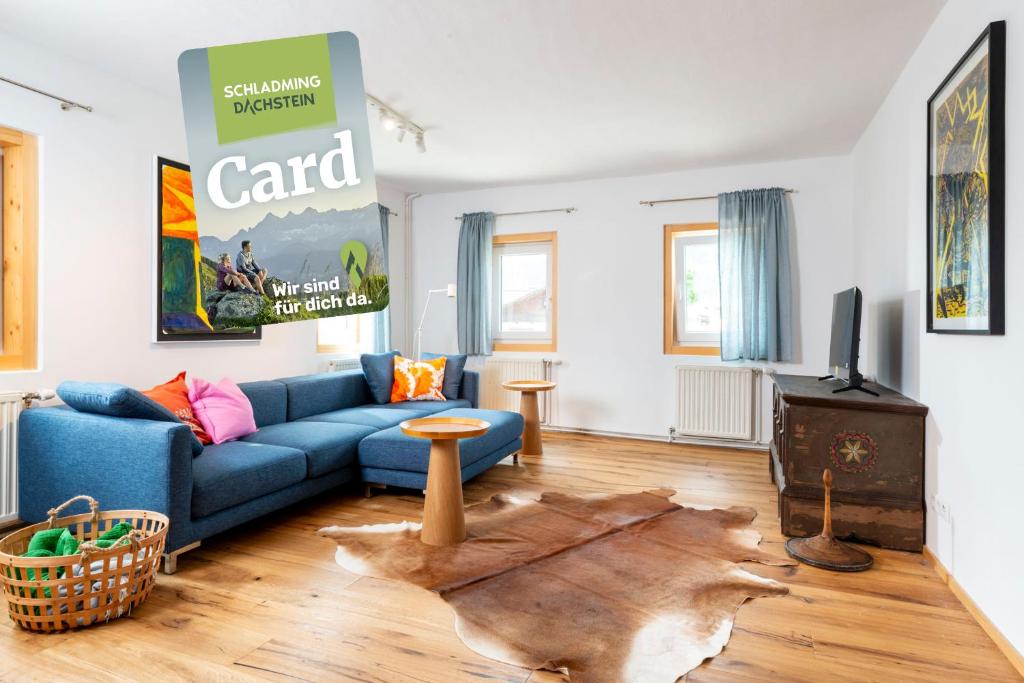 a living room with a blue couch and a tv at Apartments Sopherl - by myNests in Aich