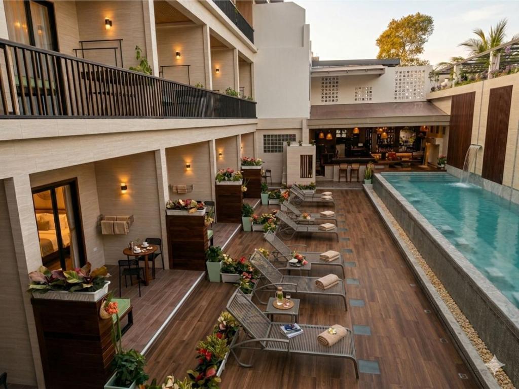 an apartment patio with a swimming pool and tables at Simple Life Resort Koh Tao in Ko Tao