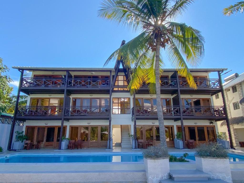 a building with a palm tree in front of it at Hôtel Baobab Café in Morondava