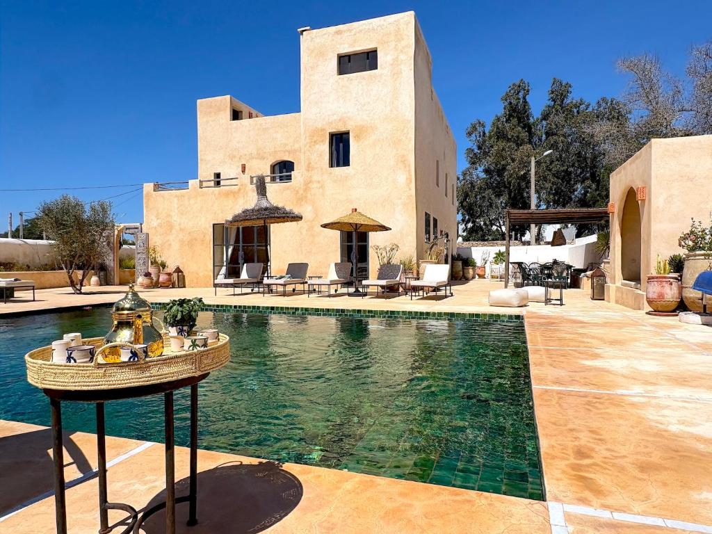a house with a swimming pool in front of a building at Palais Zoa in Essaouira