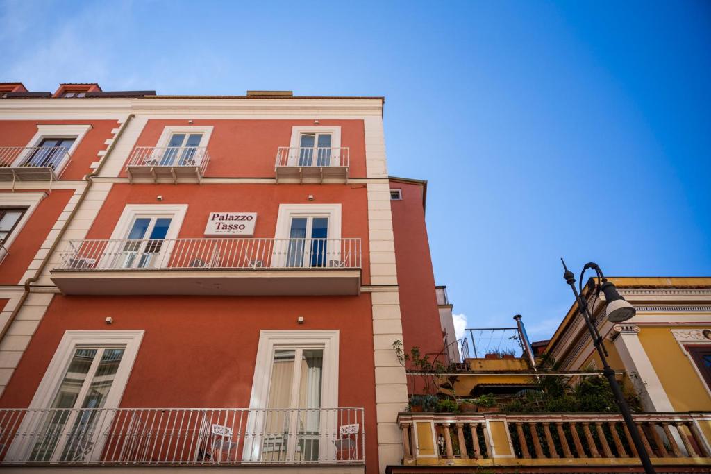 a tall red building with balconies on the side of it at Palazzo Tasso in Sorrento