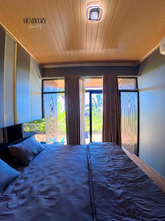 a large bed in a room with windows at Denis cozy homestay in Senaru