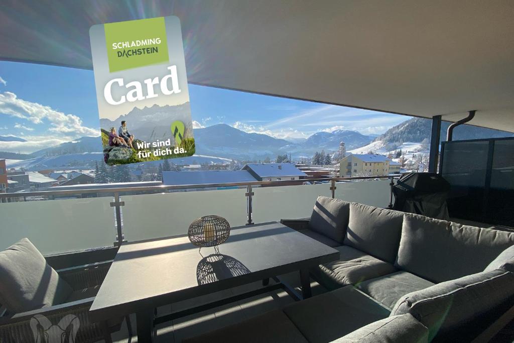 a table on a balcony with a view of the mountains at Arietem-Apartment - by myNests in Gröbming