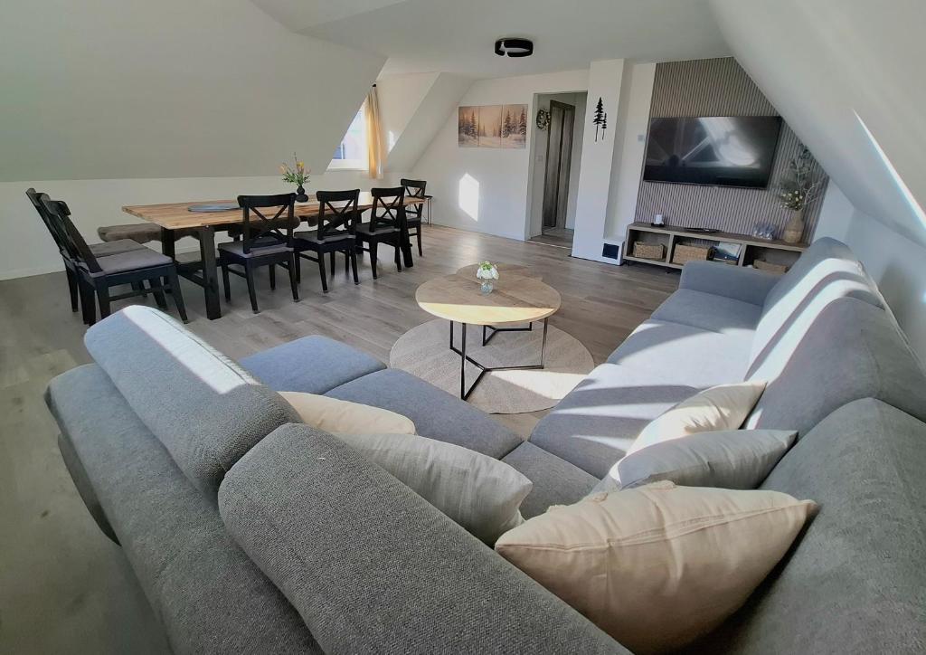 a living room with a gray couch and a table at apartmány TASIA in Mýto pod Ďumbierom