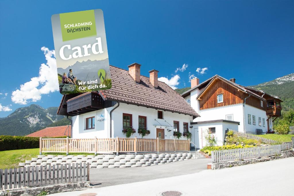a large white house with a sign in front of it at Chalet am See - by myNests in Aich