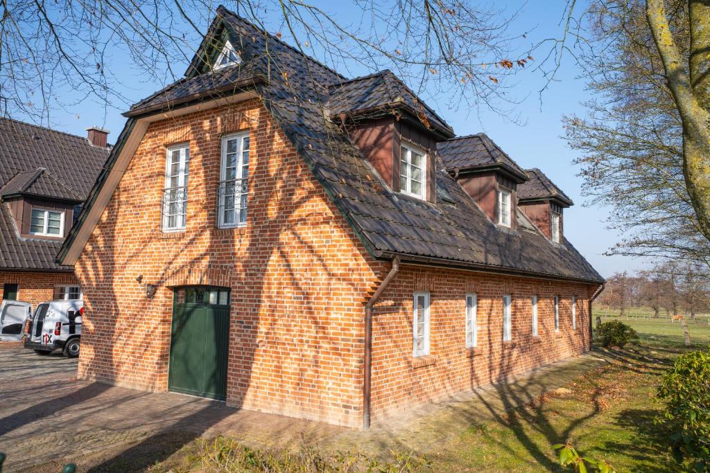 an old brick house with a black roof at Ferienwohnung Elster in Stade