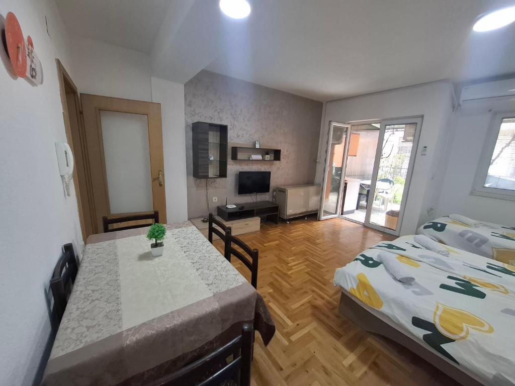 una stanza con due letti, un tavolo e una televisione di Ana Apartment a Ohrid