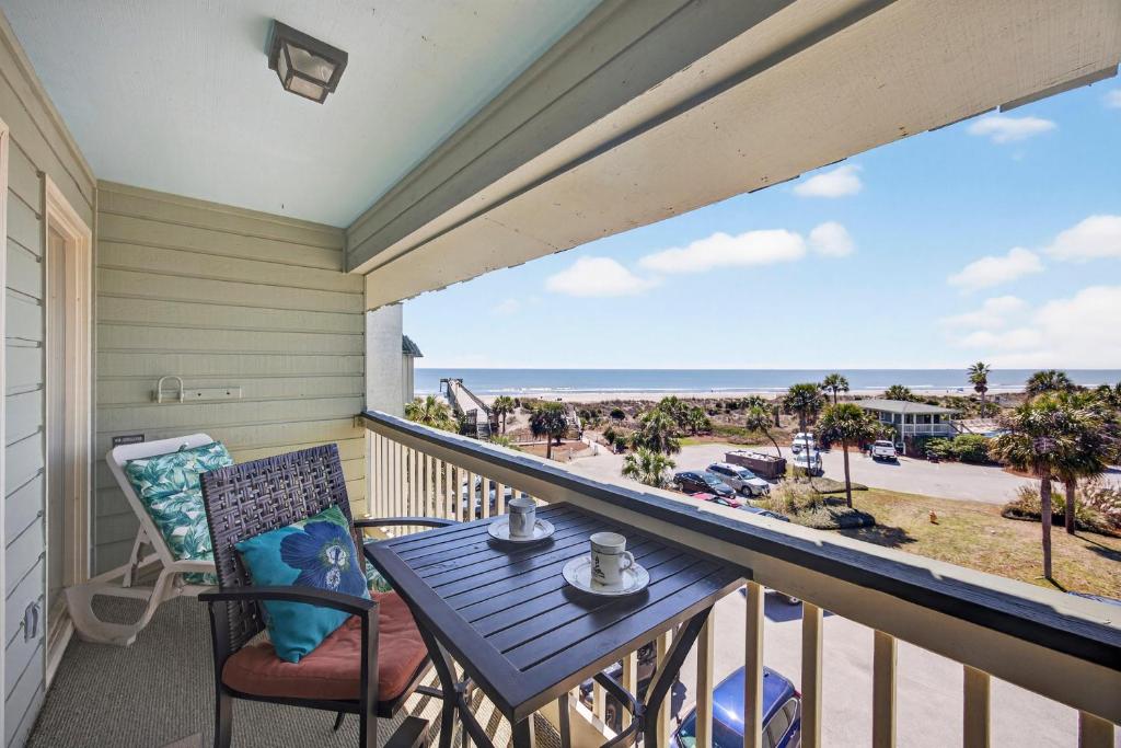a balcony with a table and chairs and a view of the beach at SC309A: 309A Sea Cabin in Isle of Palms