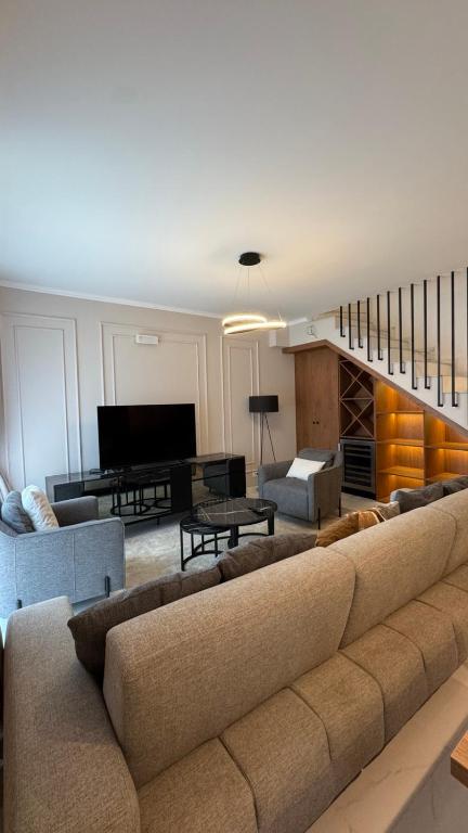 a living room with a large couch and a piano at Perla Petrus in Rafailovici