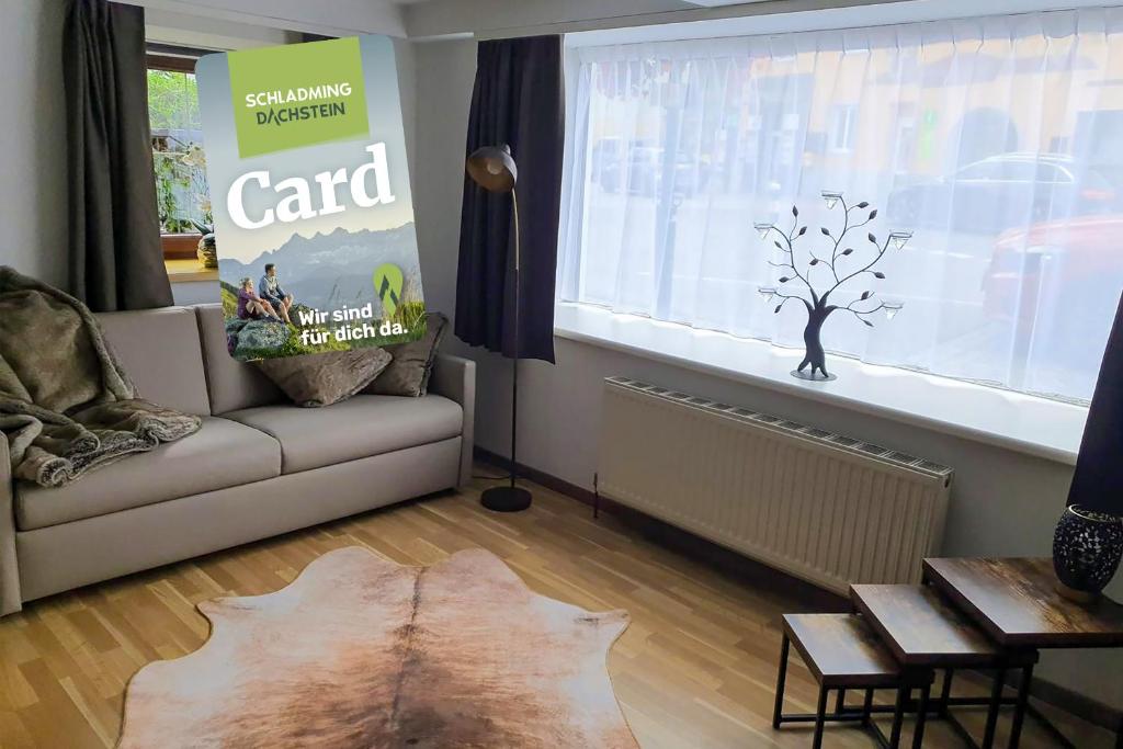a living room with a couch and a table and a window at Bachschneider Apartments - by myNests in Gröbming