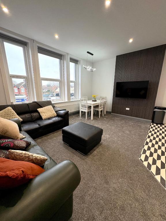 a living room with a couch and a table at Spacious 4 Bed Retreat, 2 Bath, Sleeps 8 plus 2, Beach, Bars, Dinning, Shops, Golf, for Groups, Contractors or Families in Bournemouth