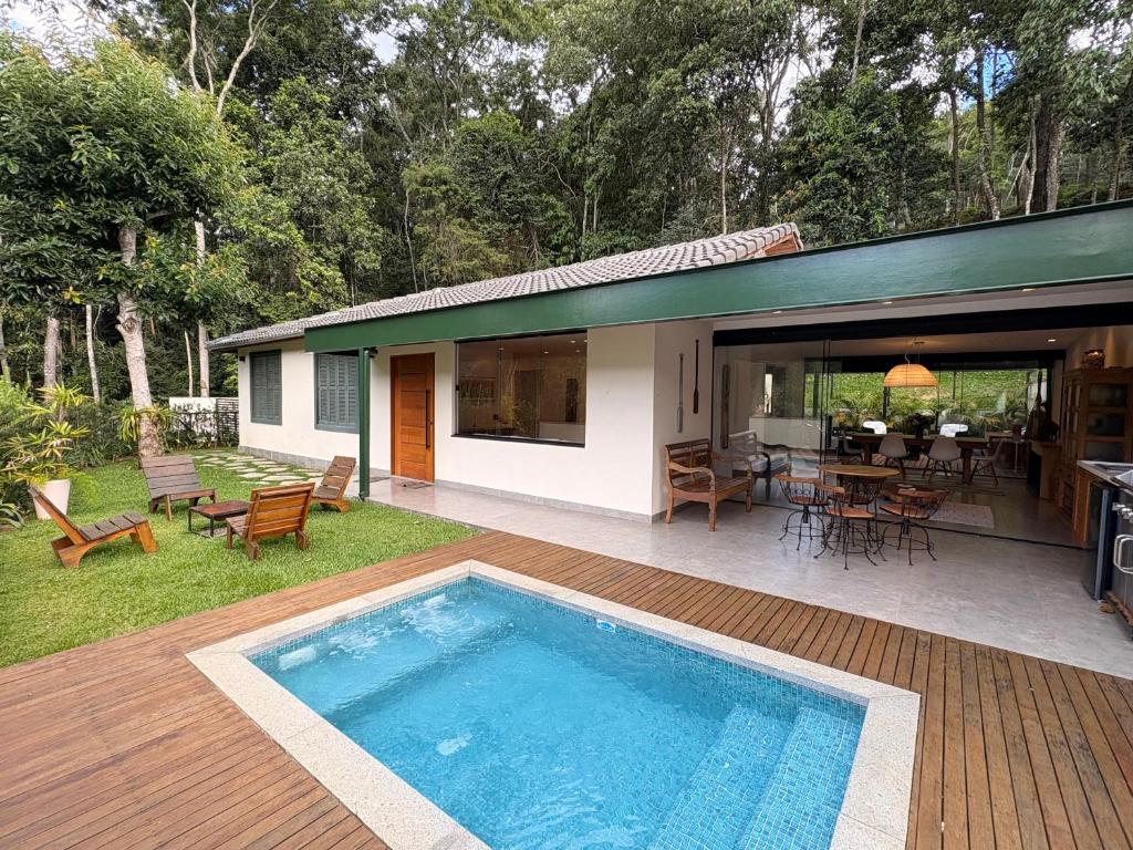 a house with a swimming pool in the yard at Casa 08 Floresta Boa Vista - Piscina Privativa e Lounge com Deck em Meio à Natureza in Teresópolis