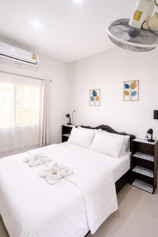 a white bedroom with a large white bed with white pillows at Yada House s&h in Nai Yang Beach
