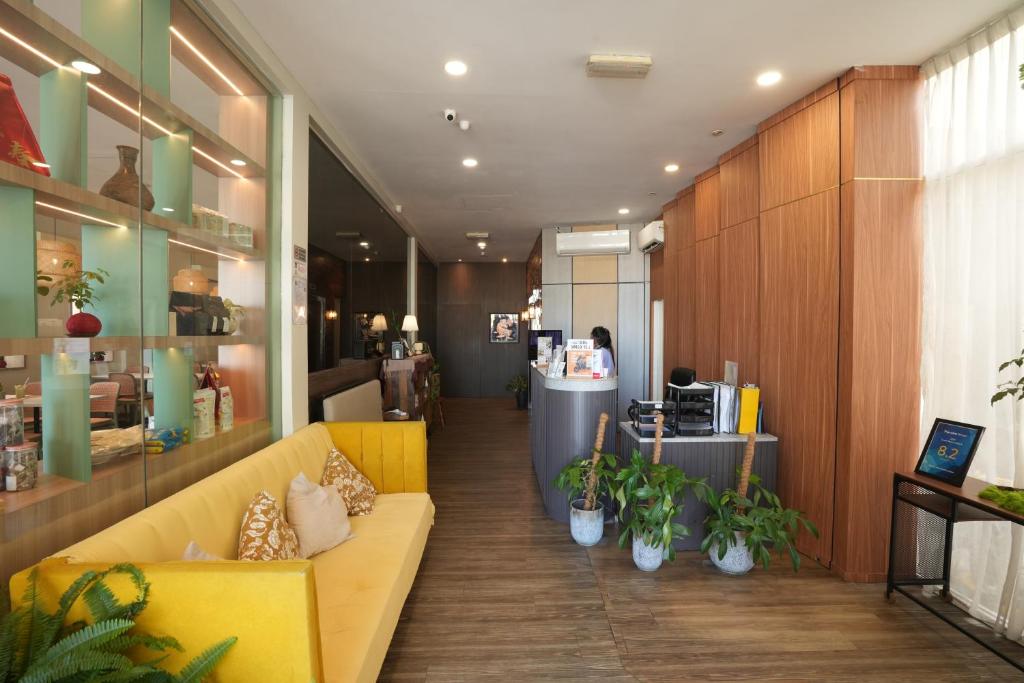 a lobby with a yellow couch and some plants at Wangs Hotel Gurney Drive in George Town