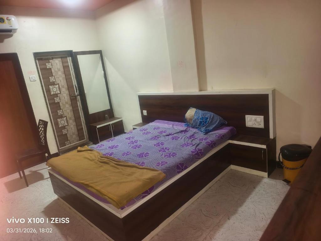 a small bedroom with a bed with purple sheets at HOTEL VISAVA GARDEN & LODGINg in Vaghunde Budrukh