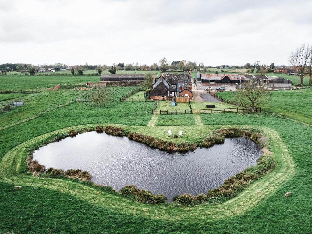 an aerial view of a farm with a heart shaped pond at 3 Woods Farm House in Chippenham