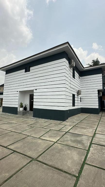 a large white building with a parking lot at House 2 Guest House - Felele in Ibadan