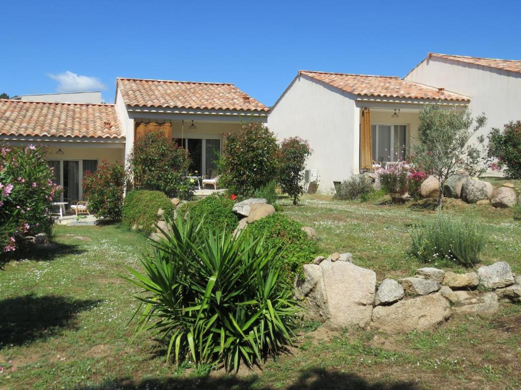 a row of houses in a yard with plants at les terrasses d'arutoli in Porto-Vecchio