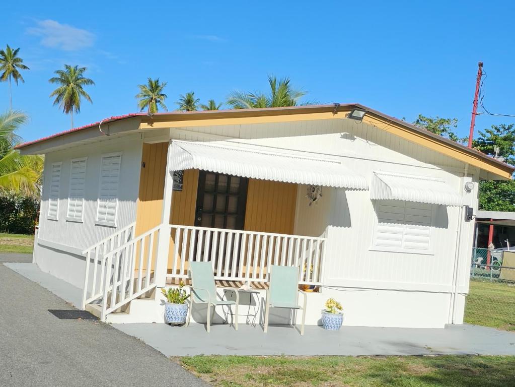 a white house with two chairs and a porch at Casita Playera Aguadeña in Tablonal