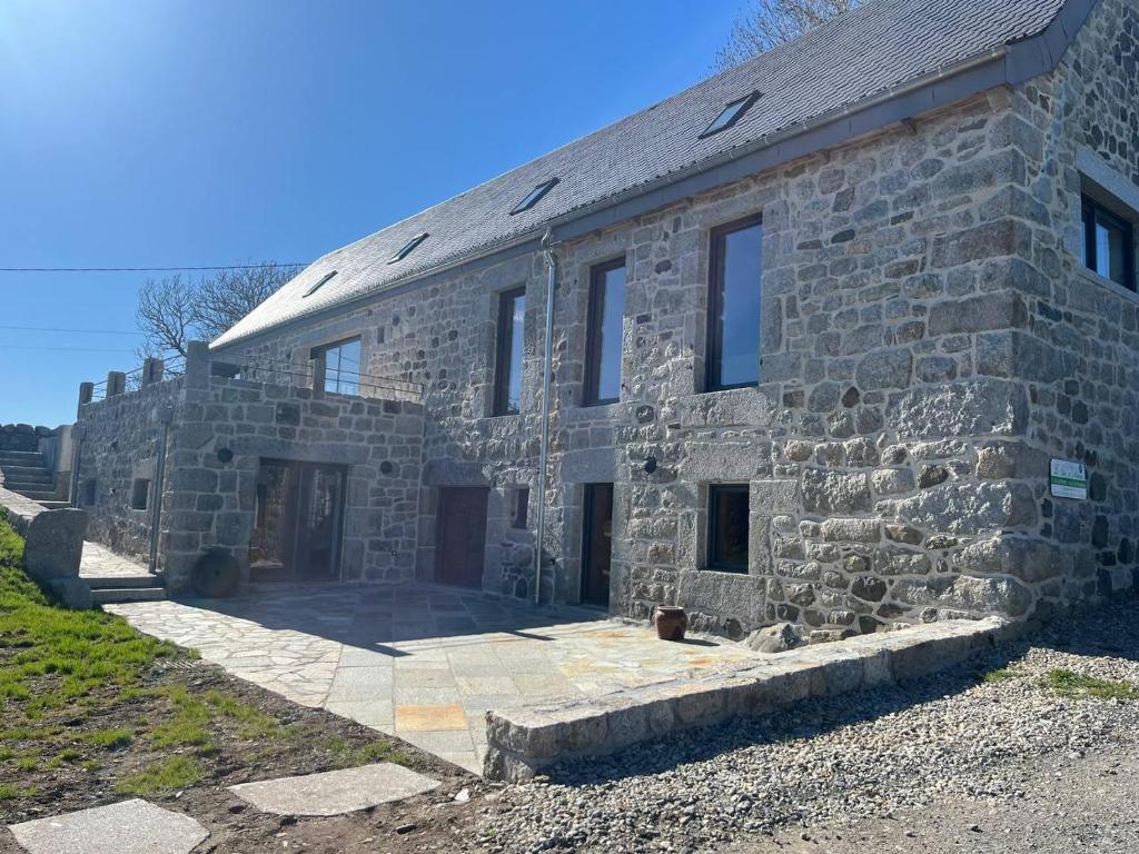 an old stone building with a door and windows at Le Ché d'Aubrac in Nasbinals