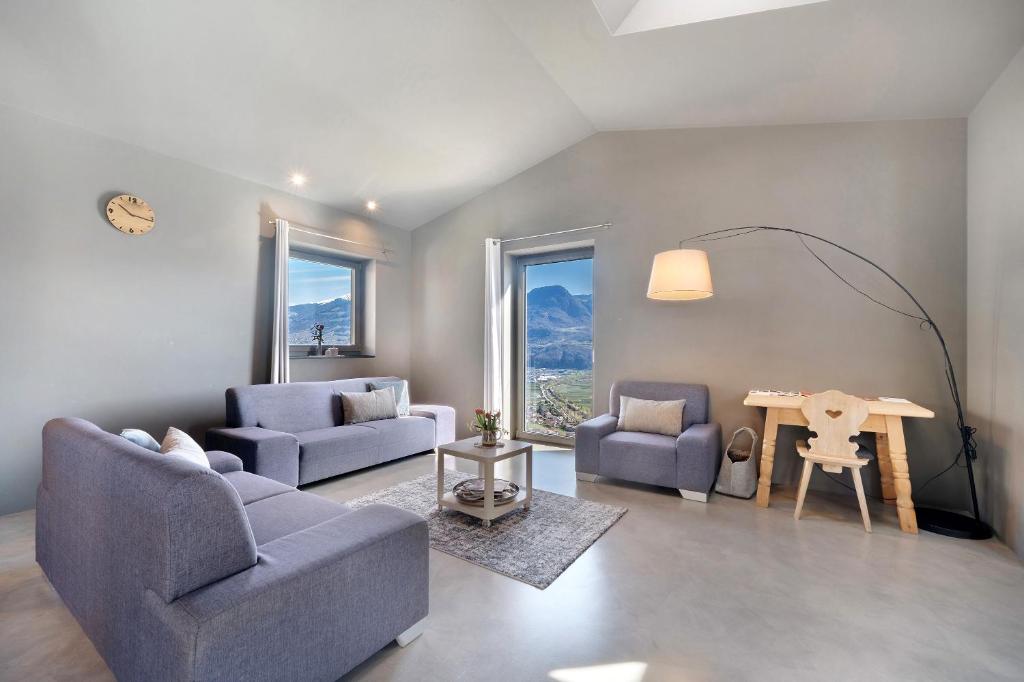 a living room with two blue chairs and a table at Apartment Am Grübl in Lana