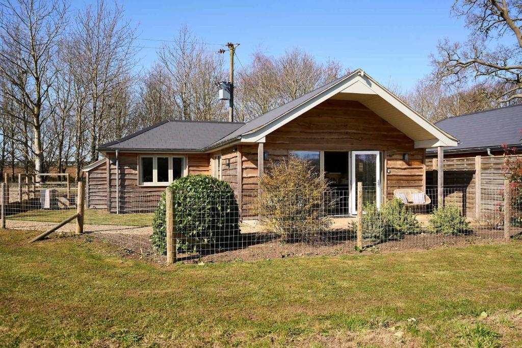 a wooden house with a fence in front of it at Host & Stay - Mole Cottage in Swannington