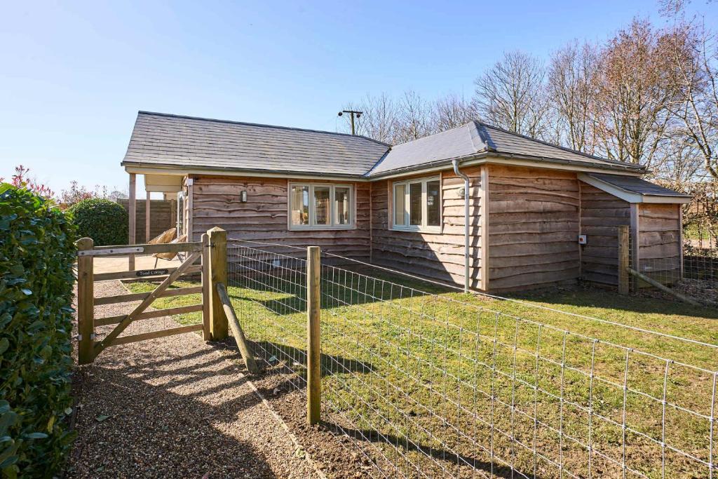 a wooden house with a fence in front of it at Host & Stay - Toad Cottage in Swannington