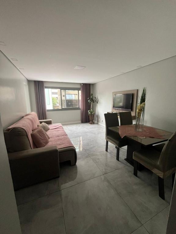 a living room with a couch and a table at Apartamento no centro de Caxias com elevador e garagem in Caxias do Sul