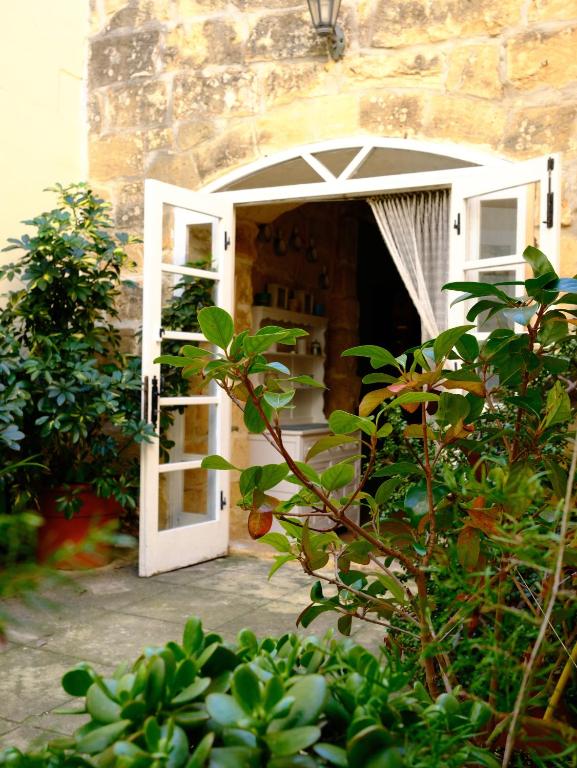 an open door to a building with an umbrella at L'Artiste Guest House in Xagħra