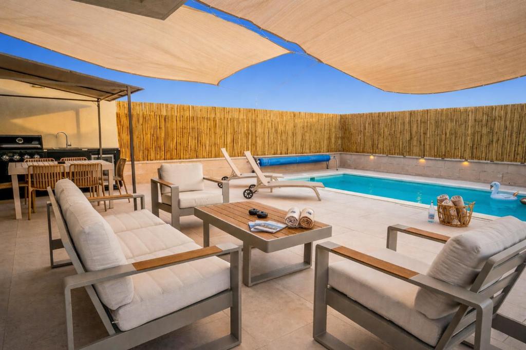 a living room with a pool with chairs and a table at וילת האושר אילת in Eilat