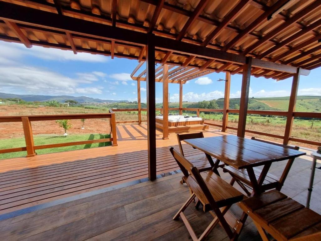 a wooden deck with a table and chairs on it at Cerrado da Canastra Chalé com Banheira in São Roque de Minas