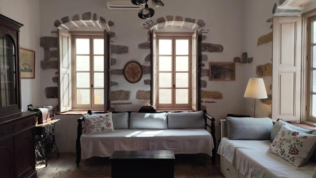 ein Wohnzimmer mit zwei Fenstern und einem Sofa in der Unterkunft En Patmo Holiday Home in Patmos
