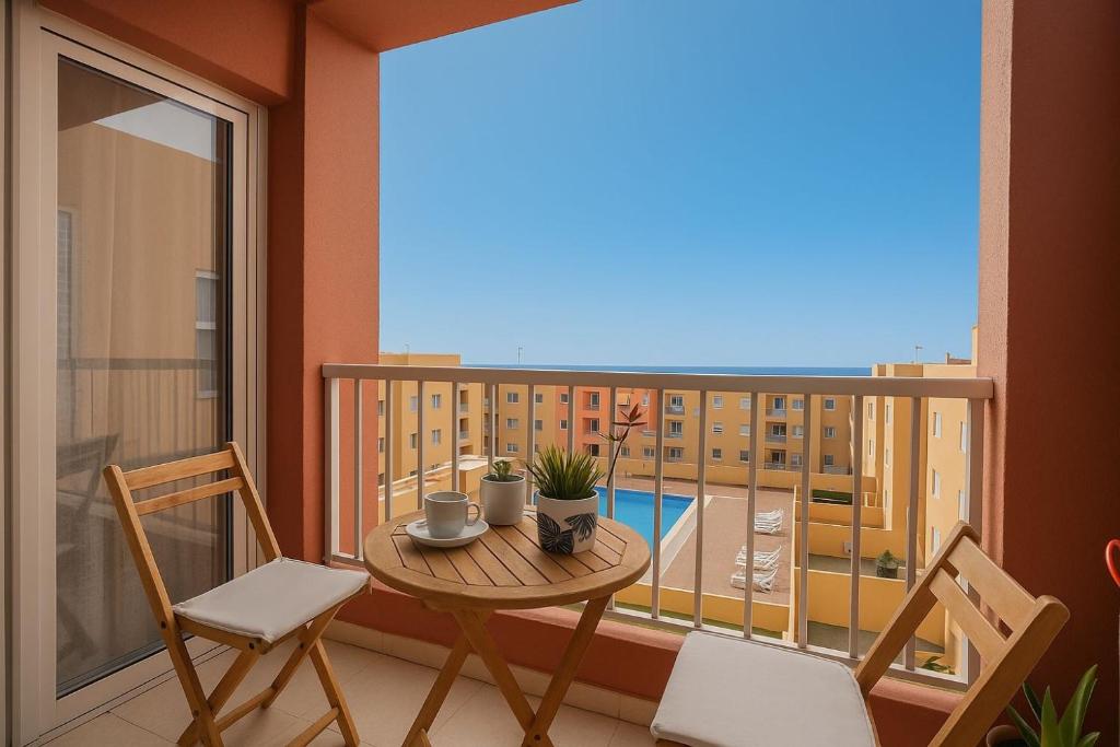 a balcony with a table and chairs and a view of a building at Apartamento Erma Candelaria in Candelaria