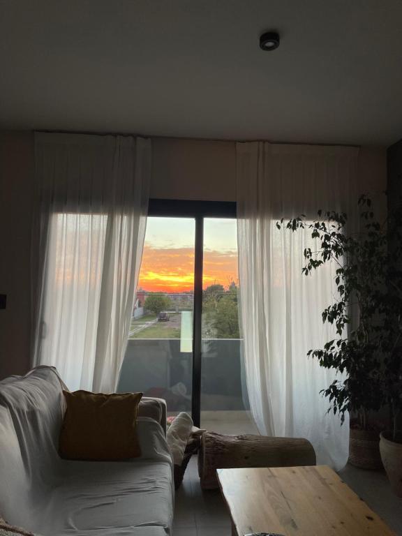 a living room with a white couch and a large window at Terruar Wine in Ciudad Lujan de Cuyo