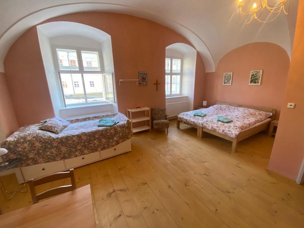 two beds in a room with two windows at Klášter Nová Říše in Nová Říše