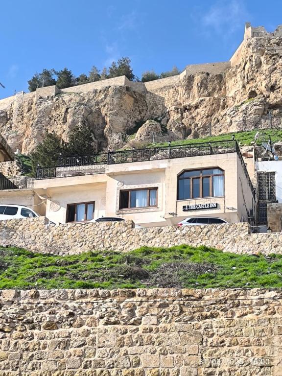 a house on the side of a rocky hill at The Castle İnn in Mardin