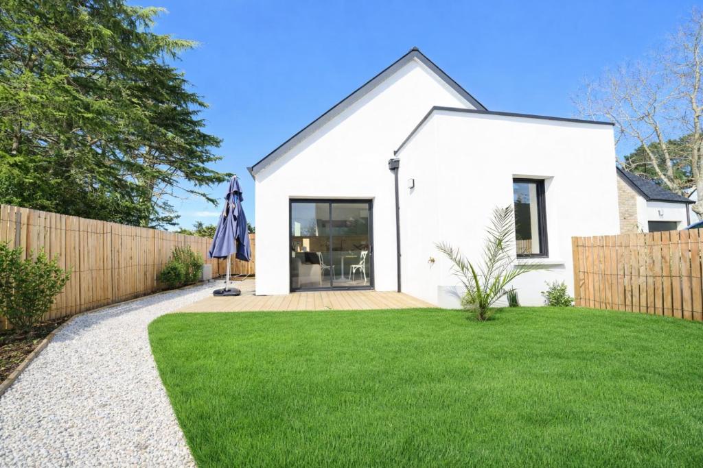 a white house with a fence and a lawn at Kercabellec entre mer et marais in Mesquer