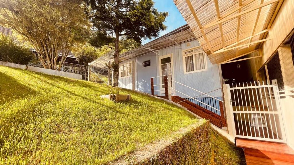 a house with a grassy yard next to a fence at Casa Próximo ao Centro e Hospital in Blumenau